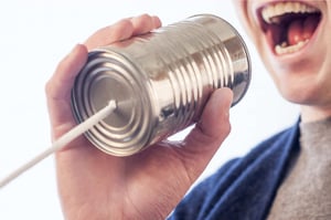 Snakker inn i en blikkboks-telefon, som bilde på utfordringen når kunder ikke svarer.
